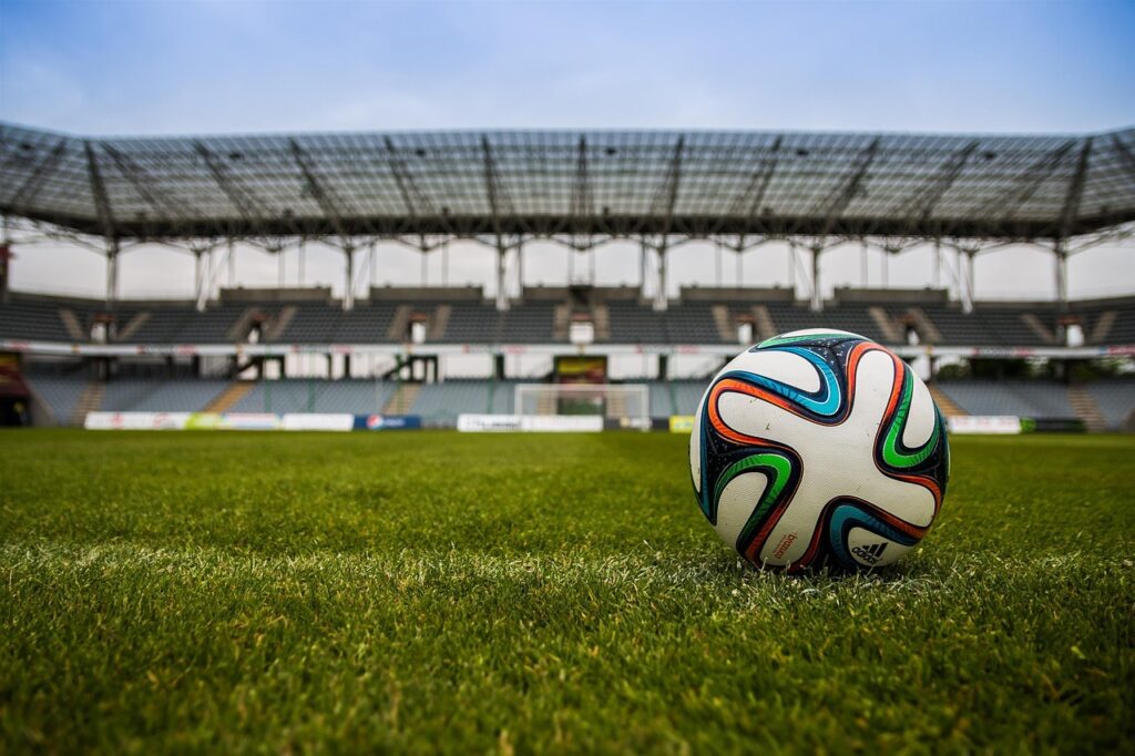 A football on the pitch under stadium lights